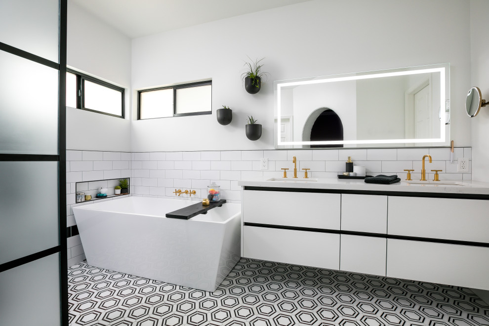 Inspiration for a contemporary master white tile and porcelain tile medium tone wood floor, brown floor, double-sink and brick wall drop-in bathtub remodel in Phoenix with flat-panel cabinets, white cabinets, white walls, a drop-in sink, quartzite countertops, white countertops and a floating vanity