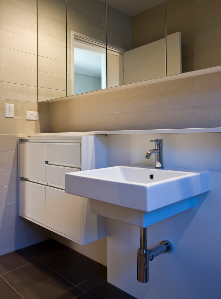 Idee per una stanza da bagno minimal di medie dimensioni con ante lisce, ante bianche, piastrelle beige, piastrelle in ceramica, pareti beige, pavimento con piastrelle in ceramica e lavabo a bacinella
