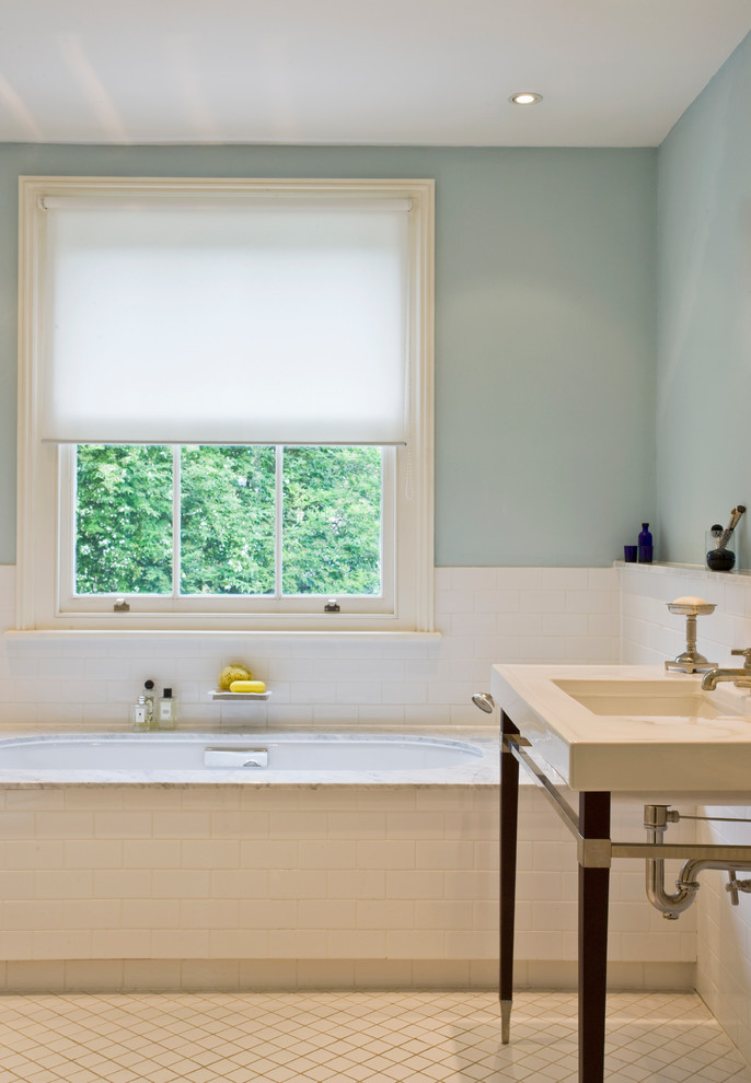 Idées déco pour une salle de bain classique avec un plan de toilette en marbre, un carrelage blanc, un plan vasque et un mur bleu.