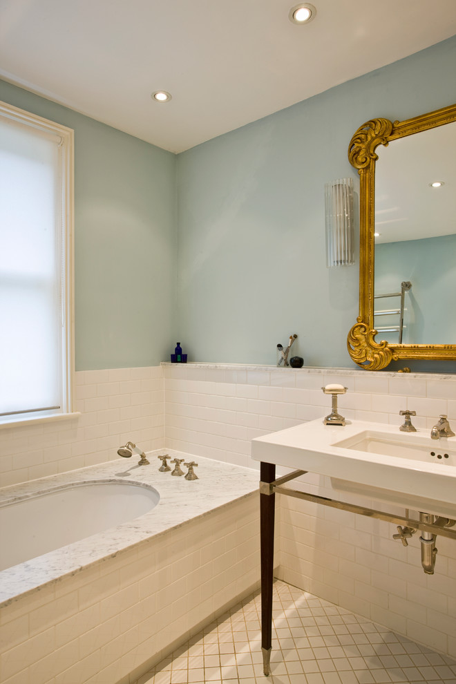 ロンドンにあるトラディショナルスタイルのおしゃれな浴室 (大理石の洗面台、白いタイル、コンソール型シンク、青い壁) の写真