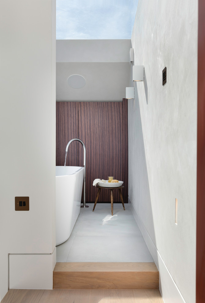 Esempio di una piccola stanza da bagno padronale design con ante lisce, ante in legno scuro e vasca freestanding