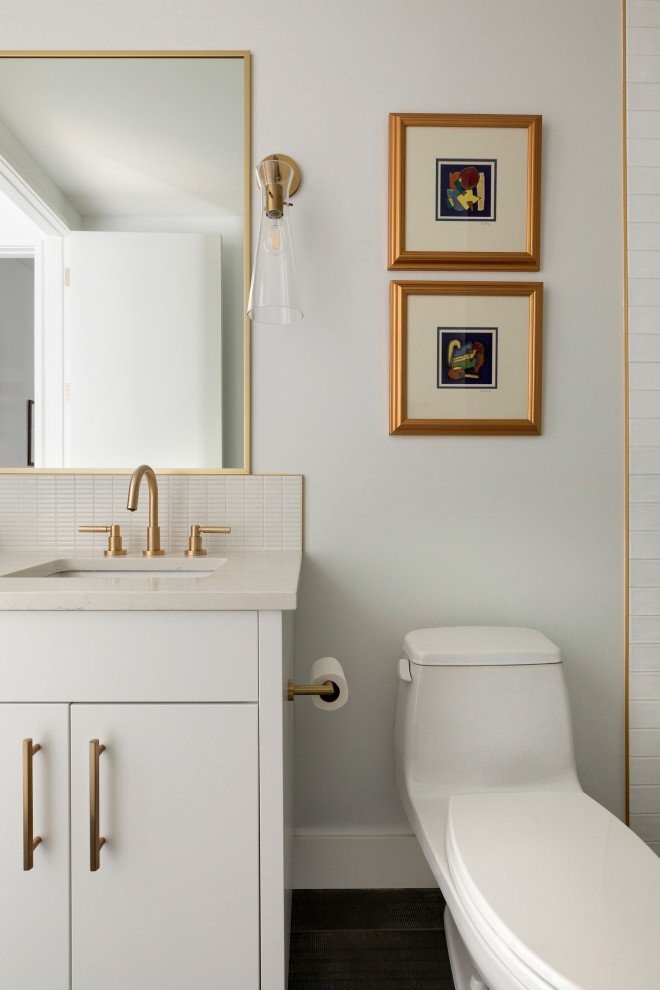 Идея дизайна: маленькая ванная комната в стиле неоклассика (современная классика) с плоскими фасадами, белыми фасадами, ванной в нише, душем над ванной, унитазом-моноблоком, белой плиткой, керамогранитной плиткой, белыми стенами, полом из терракотовой плитки, врезной раковиной, столешницей из искусственного кварца, серым полом, душем с распашными дверями и белой столешницей для на участке и в саду
