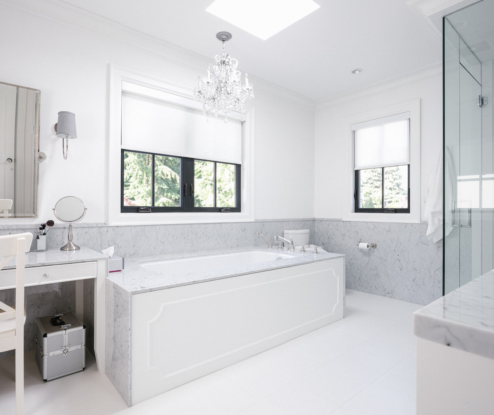 Источник вдохновения для домашнего уюта: большая главная ванная комната в стиле модернизм с белыми фасадами, полновстраиваемой ванной, угловым душем, серой плиткой, мраморной плиткой, белыми стенами, мраморной столешницей, белым полом и душем с распашными дверями