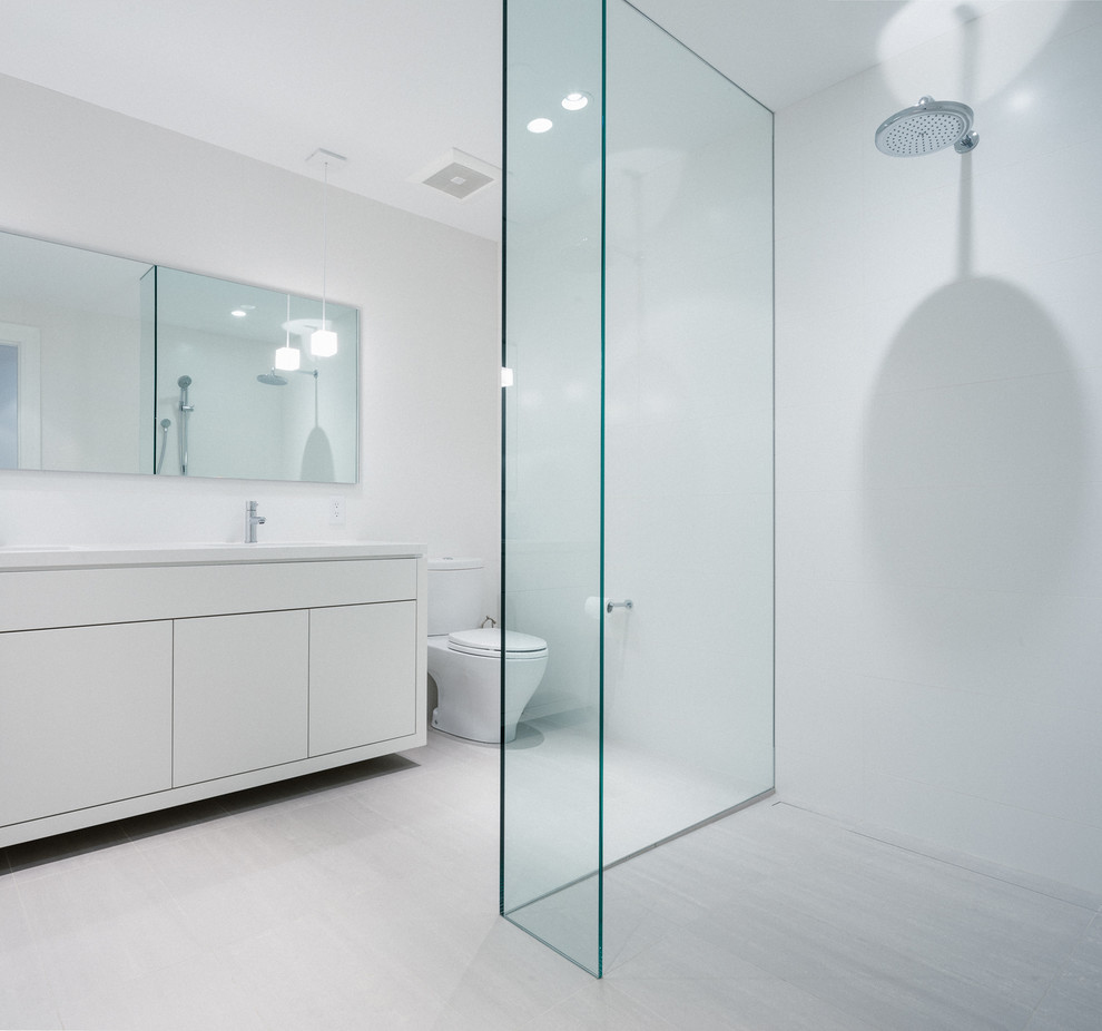 Imagen de cuarto de baño moderno con armarios con paneles lisos, puertas de armario blancas, ducha abierta, sanitario de dos piezas, baldosas y/o azulejos grises, paredes blancas, aseo y ducha y ducha abierta