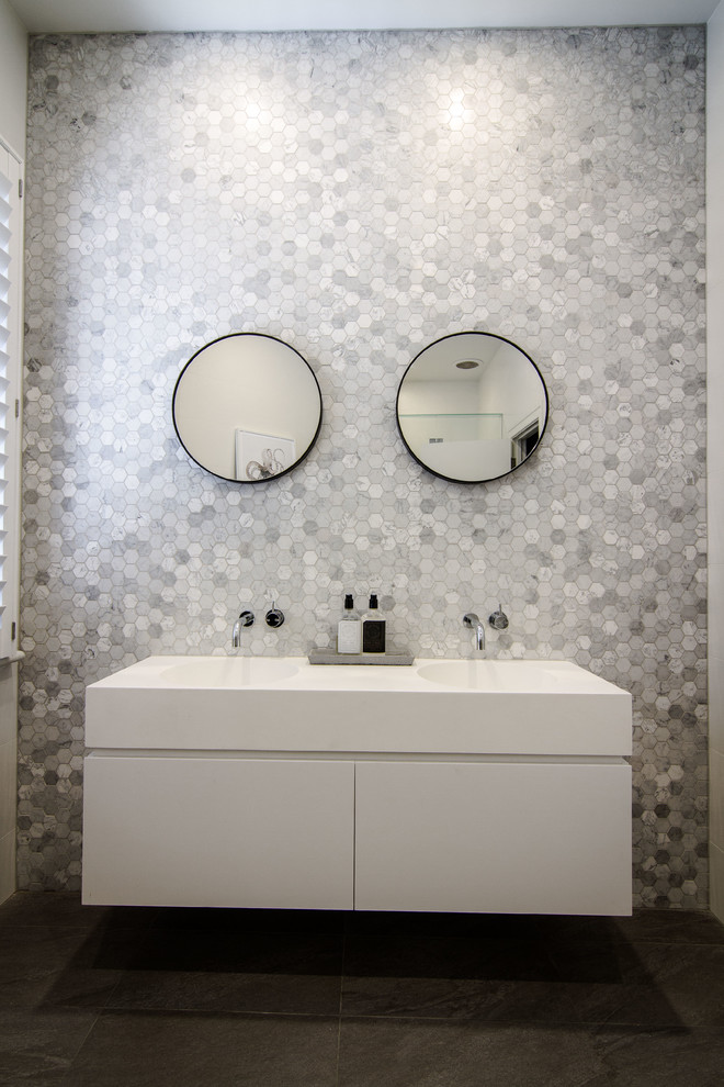 Cette image montre une salle de bain principale design de taille moyenne avec des portes de placard blanches et un plan de toilette en surface solide.