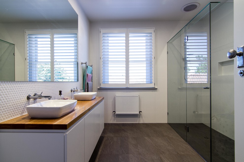 Immagine di una stanza da bagno per bambini design di medie dimensioni con ante bianche, piastrelle bianche e top in legno