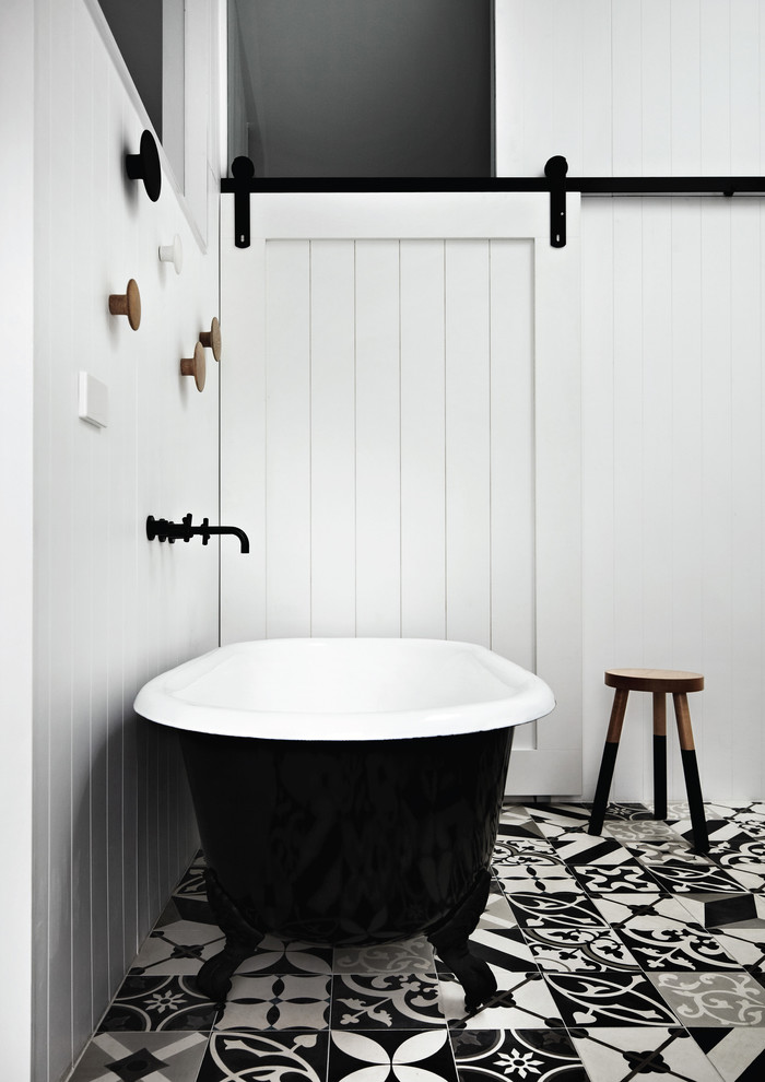 Foto de cuarto de baño azulejo de dos tonos, contemporáneo, con bañera con patas, paredes blancas, suelo de cemento y suelo multicolor