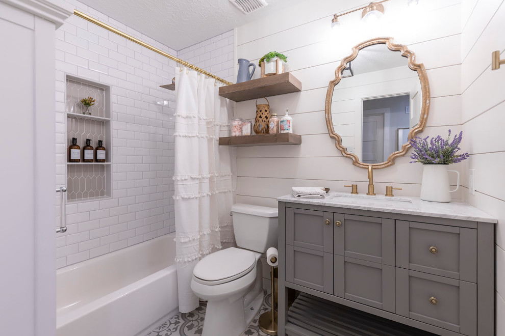 Idée de décoration pour une salle de bain champêtre avec des portes de placard grises, une baignoire en alcôve, un combiné douche/baignoire, un mur blanc, un lavabo encastré, un sol multicolore, une cabine de douche avec un rideau, un plan de toilette blanc et un placard à porte shaker.