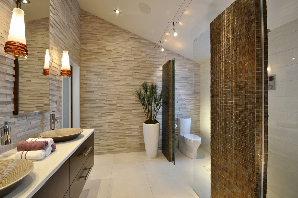 Contemporary bathroom in Milwaukee with a vessel sink, freestanding cabinets, dark wood cabinets, engineered stone worktops, a built-in shower, a two-piece toilet, grey tiles and stone tiles.