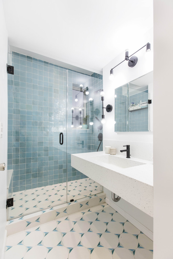 Источник вдохновения для домашнего уюта: ванная комната в современном стиле с белыми фасадами, синей плиткой, душевой кабиной, монолитной раковиной, разноцветным полом, душем с распашными дверями, тумбой под одну раковину и подвесной тумбой