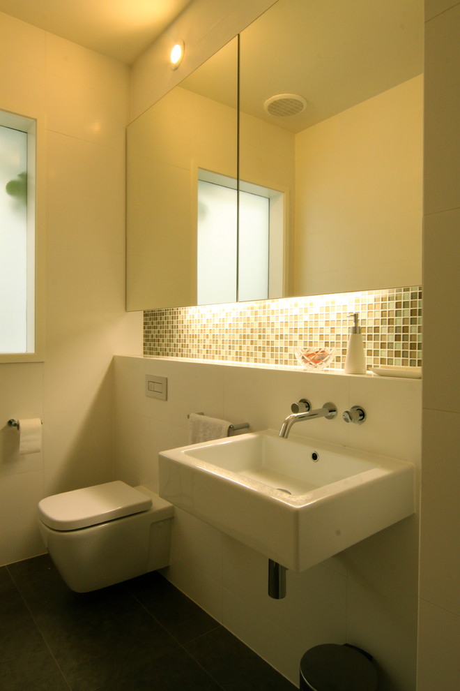 メルボルンにあるお手頃価格の小さなコンテンポラリースタイルのおしゃれな浴室 (壁付け型シンク、壁掛け式トイレ、白い壁、セラミックタイルの床) の写真