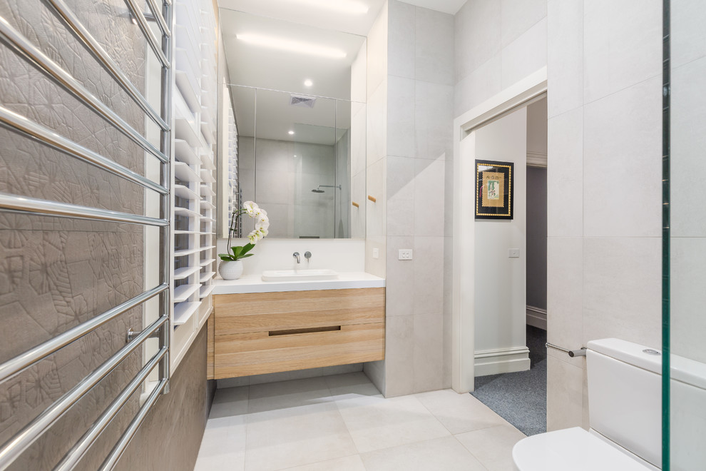 Inredning av ett modernt mellanstort en-suite badrum, med en öppen dusch, ett nedsänkt handfat, skåp i ljust trä, ett hörnbadkar, cementkakel, grå väggar, marmorgolv, granitbänkskiva, vitt golv och med dusch som är öppen