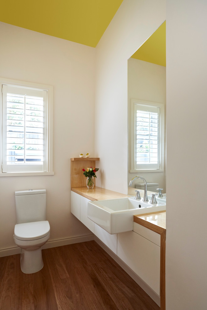 Exempel på ett stort modernt brun brunt en-suite badrum, med släta luckor, vita skåp, träbänkskiva, ett fristående badkar, en dusch i en alkov, en toalettstol med hel cisternkåpa, vita väggar och mellanmörkt trägolv