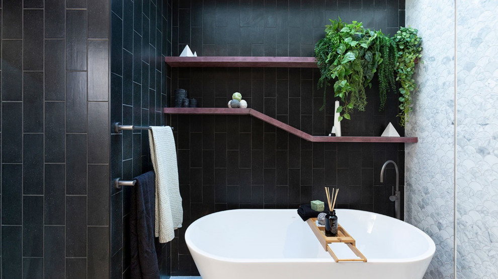 Bathroom - mid-sized industrial kids' black tile and ceramic tile ceramic tile, gray floor and double-sink bathroom idea in London with flat-panel cabinets, white cabinets, a one-piece toilet, gray walls, a vessel sink, solid surface countertops, white countertops and a floating vanity