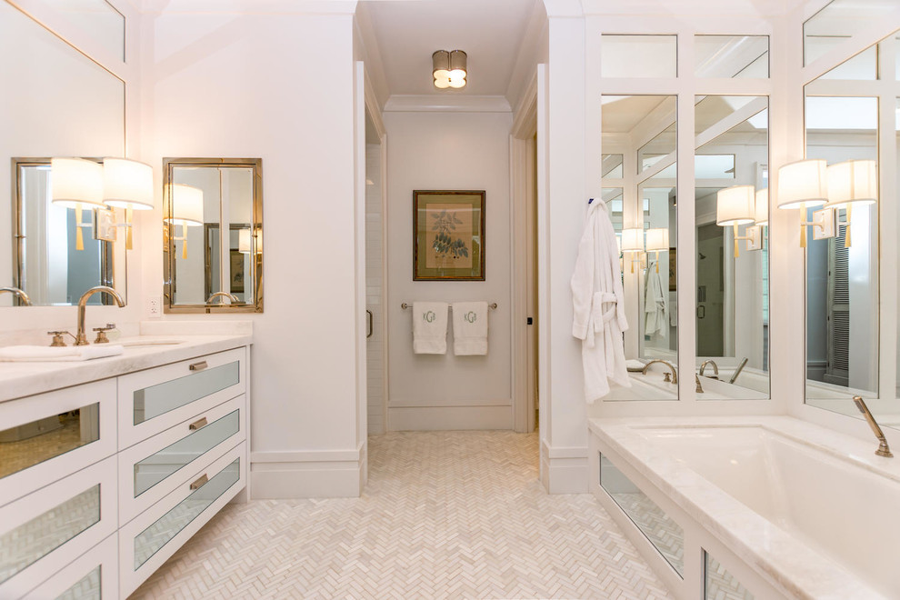 Photo of a large ensuite bathroom in Miami with glass-front cabinets, white cabinets, a built-in bath, beige tiles, mosaic tiles, white walls, limestone flooring, an integrated sink and marble worktops.