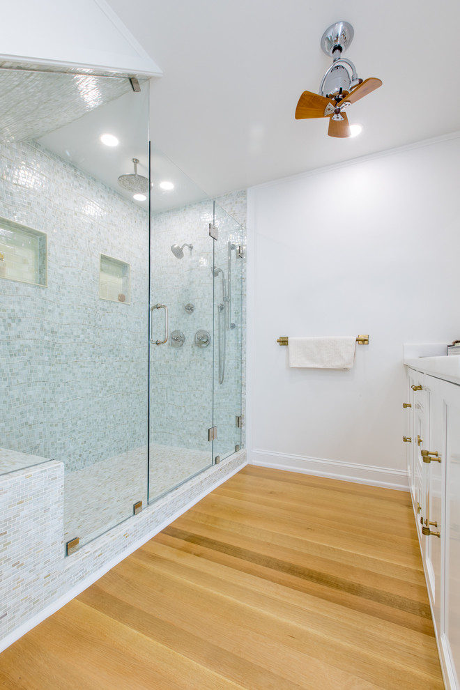 Large beach style master medium tone wood floor and multicolored floor double shower photo in Miami with beaded inset cabinets, white cabinets, white walls and a hinged shower door