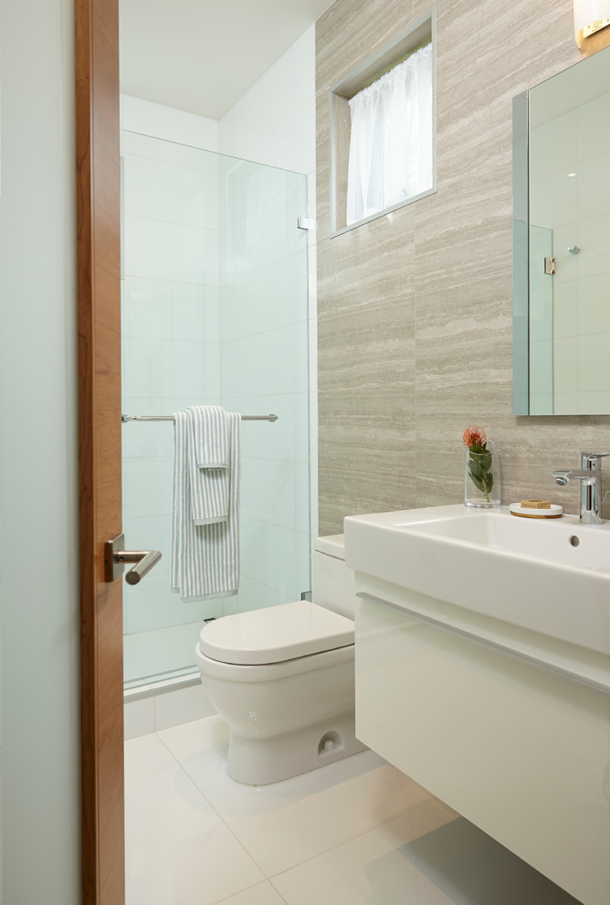 Photo of a small contemporary family bathroom in Miami with beaded cabinets, white cabinets, a corner shower, a two-piece toilet, multi-coloured tiles, glass tiles, multi-coloured walls, marble flooring, an integrated sink and solid surface worktops.
