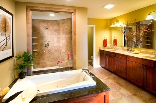 Esempio di una grande stanza da bagno padronale tradizionale con ante in stile shaker, ante in legno scuro, vasca da incasso, doccia alcova, piastrelle beige, piastrelle in pietra, pareti beige e lavabo integrato
