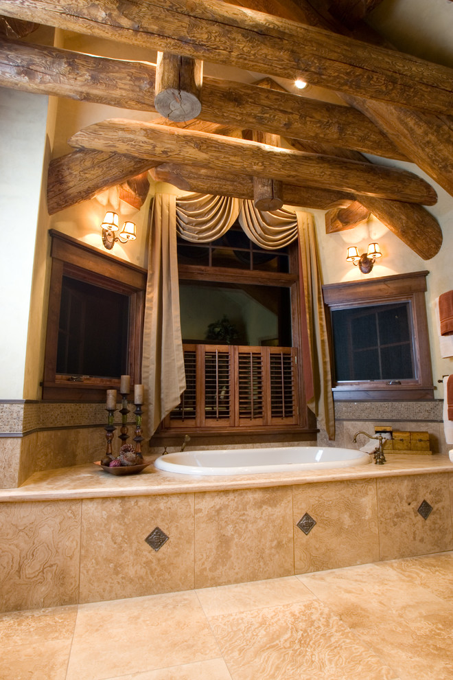Exempel på ett mycket stort rustikt en-suite badrum, med ett platsbyggt badkar och beige kakel