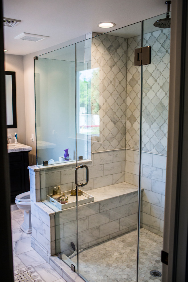 Cette image montre une grande salle de bain principale chalet en bois foncé avec une douche d'angle, un carrelage gris, un mur gris, une cabine de douche à porte battante, un placard avec porte à panneau encastré, un lavabo encastré et un sol blanc.