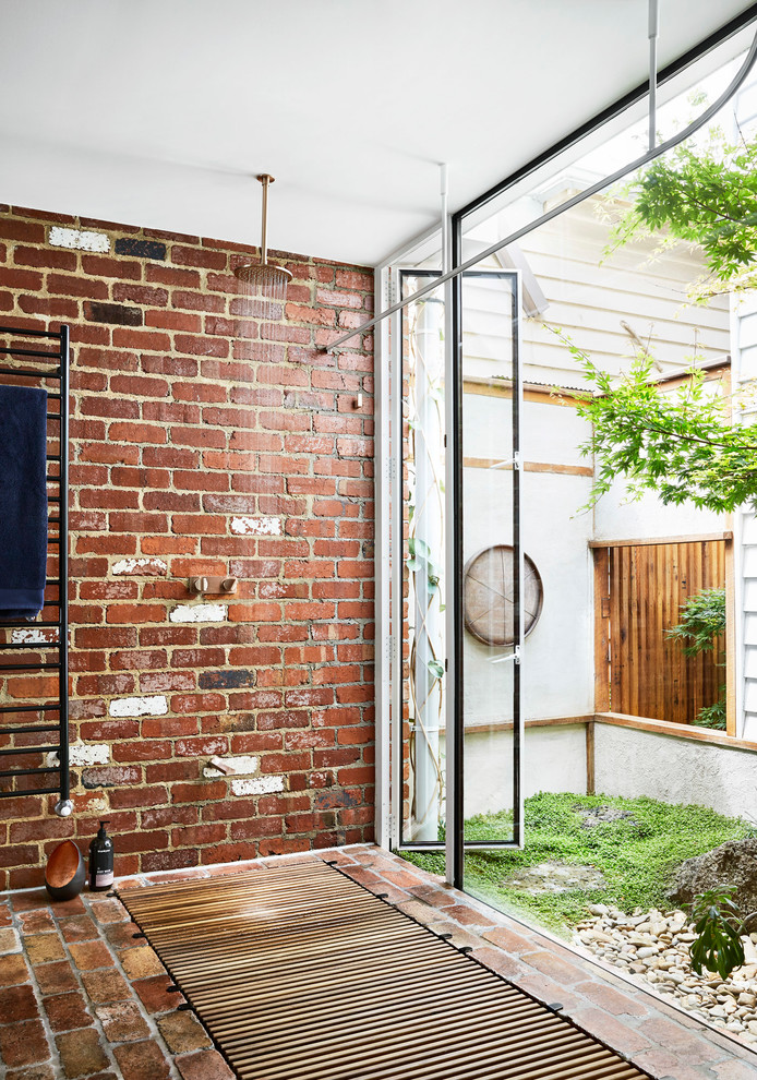 This is an example of a contemporary bathroom in Melbourne with a built-in shower, red walls, brick flooring and an open shower.
