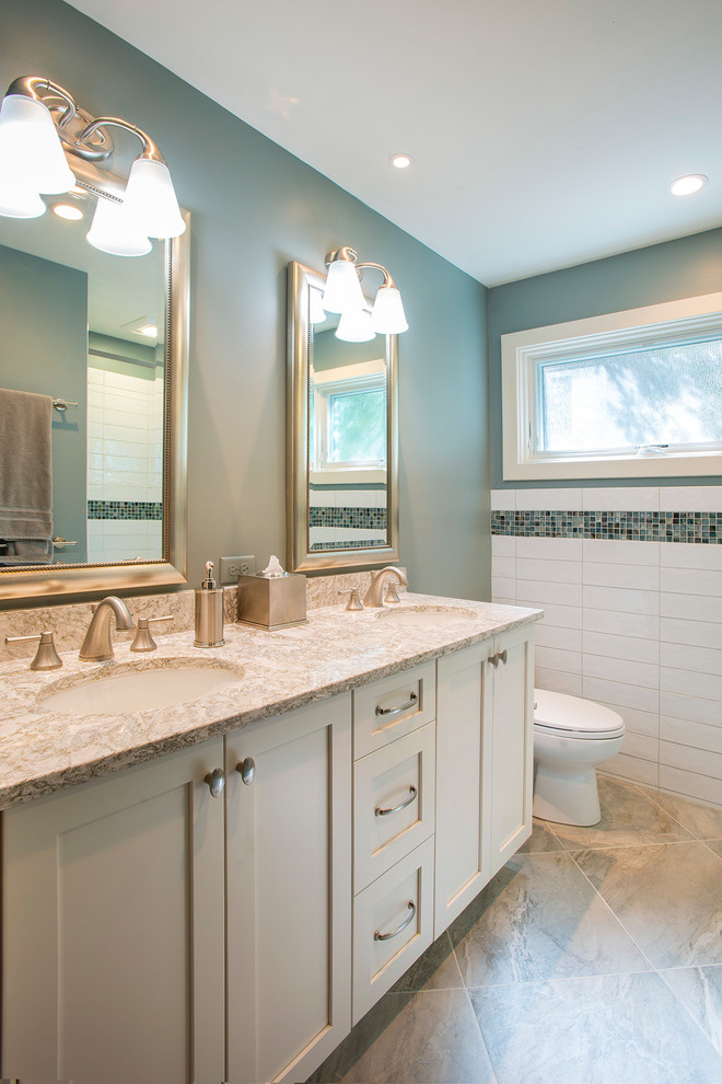 Inspiration for a small transitional white tile and ceramic tile ceramic tile and gray floor bathroom remodel in Charleston with recessed-panel cabinets, white cabinets, a two-piece toilet, green walls, an undermount sink and quartz countertops