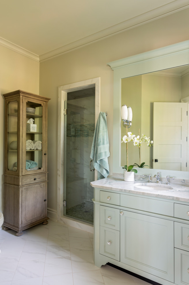 Beach style white floor alcove shower photo in Charleston with recessed-panel cabinets, gray cabinets, beige walls, an undermount sink, a hinged shower door, white countertops and a built-in vanity