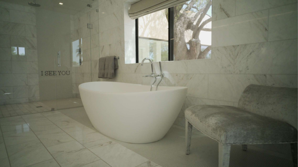 Idéer för att renovera ett stort funkis en-suite badrum, med släta luckor, skåp i mellenmörkt trä, ett fristående badkar, våtrum, en toalettstol med hel cisternkåpa, vit kakel, marmorkakel, vita väggar, marmorgolv, ett avlångt handfat, marmorbänkskiva, vitt golv och dusch med gångjärnsdörr