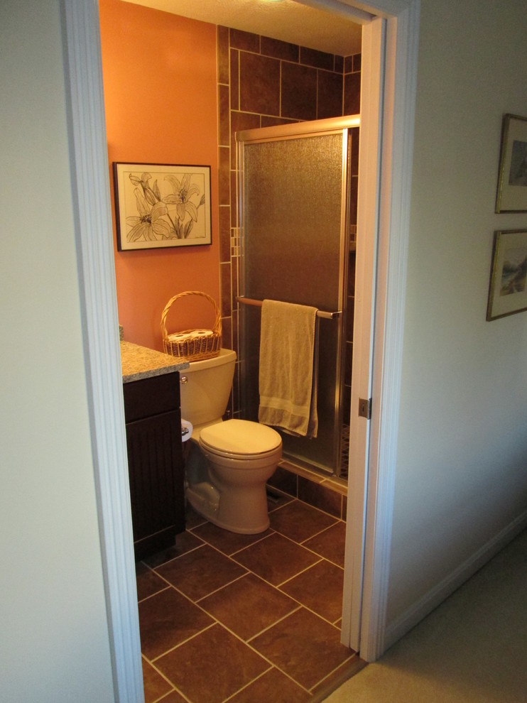Alcove shower - small contemporary 3/4 brown tile and porcelain tile porcelain tile alcove shower idea in Indianapolis with an undermount sink, beaded inset cabinets, dark wood cabinets, granite countertops, a two-piece toilet and orange walls