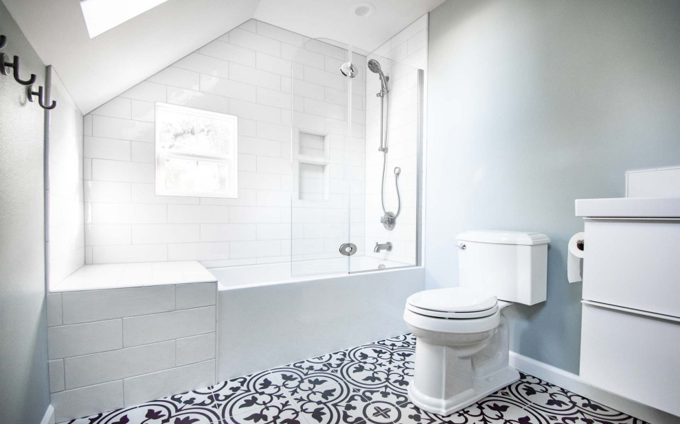 Photo of a medium sized classic family bathroom in Portland with flat-panel cabinets, white cabinets, an alcove bath, a shower/bath combination, a two-piece toilet, white tiles, metro tiles, grey walls, ceramic flooring, a submerged sink, engineered stone worktops, white floors, a hinged door, white worktops, a wall niche, a single sink and a floating vanity unit.