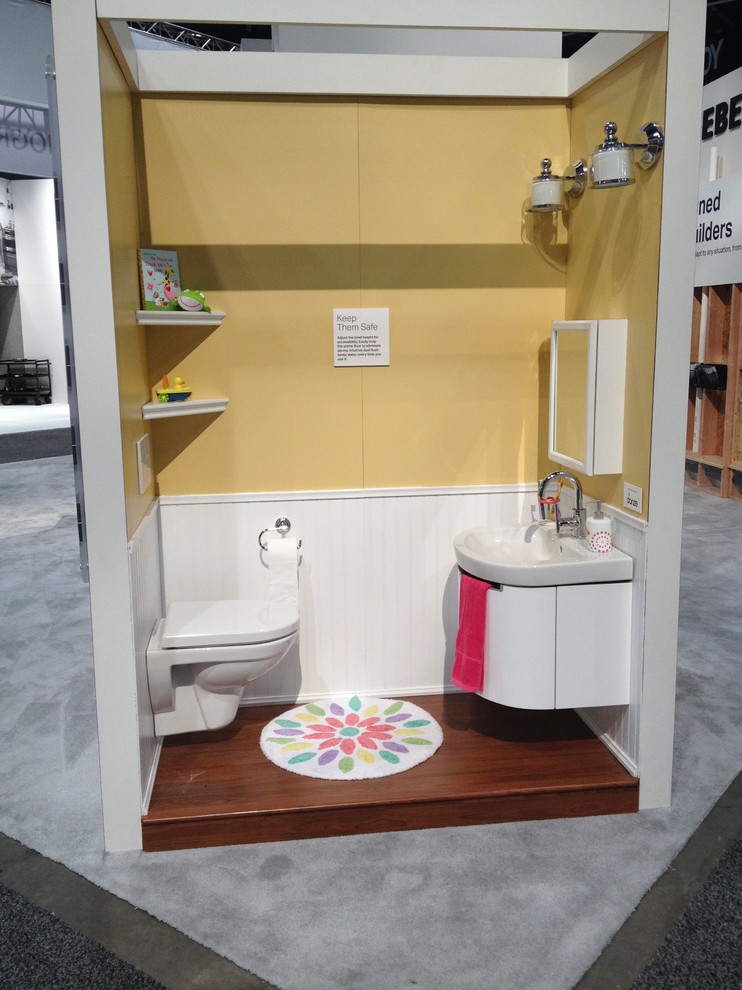 Inspiration för små moderna badrum för barn, med ett väggmonterat handfat, en vägghängd toalettstol, gula väggar och mörkt trägolv