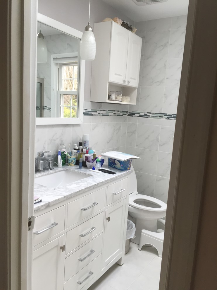 Cette image montre une petite salle de bain minimaliste pour enfant avec un placard à porte affleurante, des portes de placard blanches, une baignoire posée, WC à poser, un carrelage multicolore, des carreaux de béton, un sol en carrelage de porcelaine et un plan de toilette en granite.