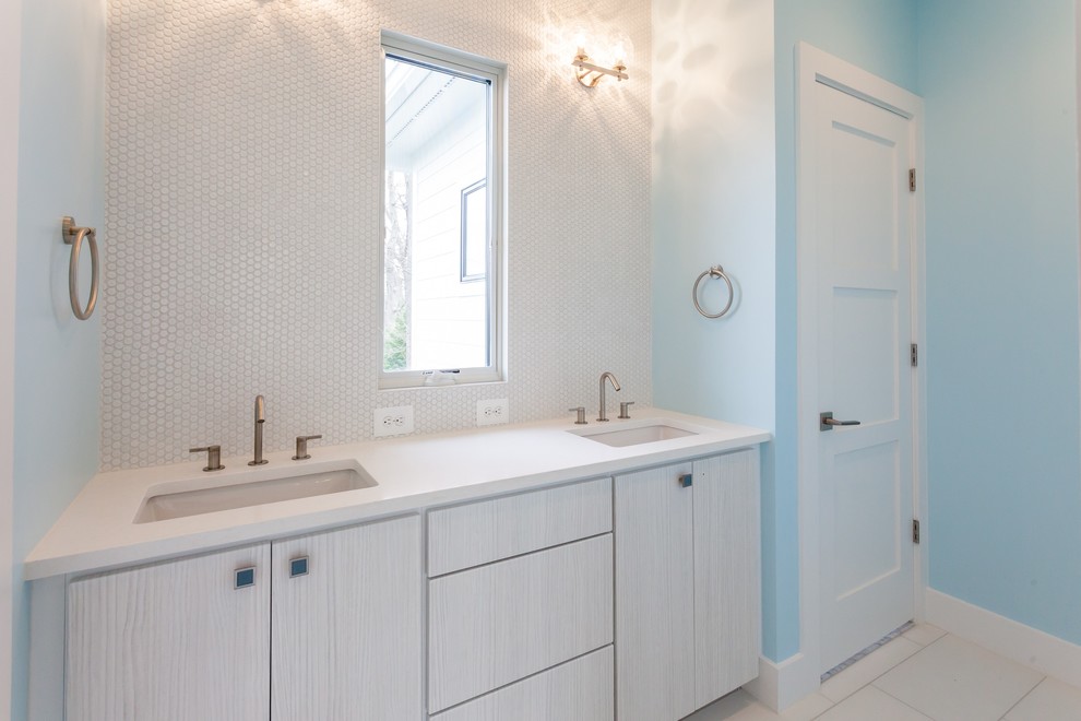 Example of a trendy kids' white tile beige floor bathroom design in DC Metro with flat-panel cabinets, light wood cabinets, a two-piece toilet, blue walls, an undermount sink and white countertops