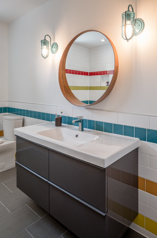 Medium sized contemporary family bathroom in Ottawa with flat-panel cabinets, grey cabinets, multi-coloured tiles, ceramic tiles, solid surface worktops, an alcove bath, a shower/bath combination, a two-piece toilet, grey walls, ceramic flooring and an integrated sink.