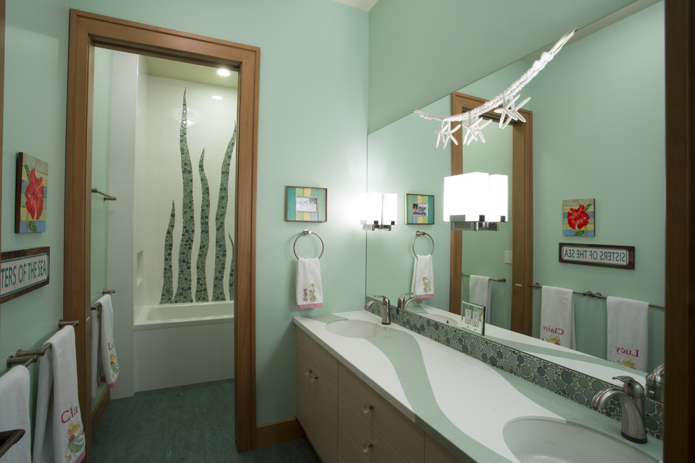 Large classic family bathroom in Seattle with a submerged sink, flat-panel cabinets, light wood cabinets, solid surface worktops, an alcove bath, a shower/bath combination, a wall mounted toilet, beige tiles, glass tiles, green walls and lino flooring.