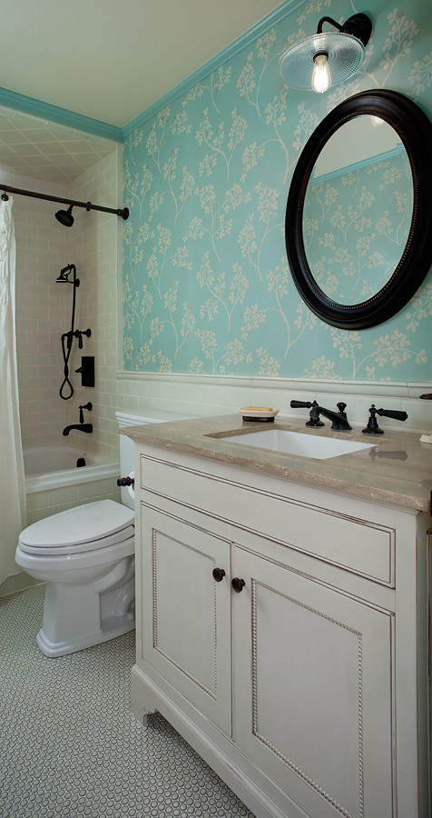 Example of a beach style white tile and mosaic tile ceramic tile drop-in bathtub design in Grand Rapids with an undermount sink, beaded inset cabinets, distressed cabinets, limestone countertops and a two-piece toilet