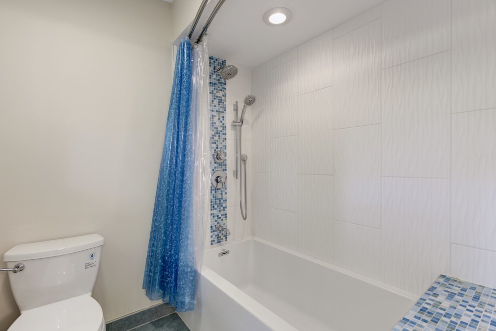 Cette photo montre une grande salle de bain principale rétro avec un placard à porte shaker, des portes de placard blanches, une baignoire en alcôve, un combiné douche/baignoire, WC séparés, un carrelage bleu, mosaïque, un mur beige, un sol en carrelage de porcelaine, un lavabo encastré, un plan de toilette en stéatite, un sol bleu et une cabine de douche avec un rideau.