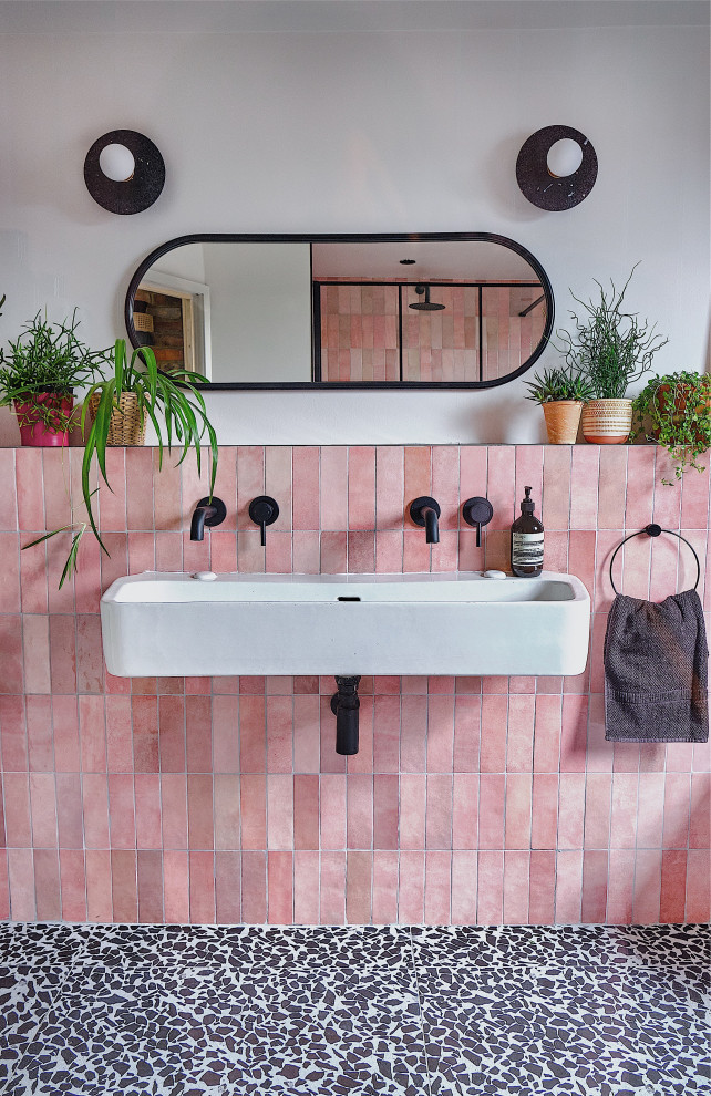 Idéer för ett mellanstort modernt badrum för barn, med svarta skåp, en öppen dusch, en vägghängd toalettstol, rosa kakel, keramikplattor, vita väggar, terrazzogolv, ett avlångt handfat, svart golv och med dusch som är öppen