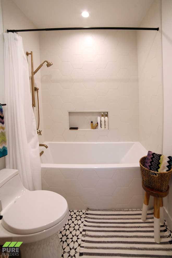 Inredning av ett modernt litet vit vitt badrum med dusch, med släta luckor, skåp i ljust trä, ett badkar i en alkov, en dusch/badkar-kombination, en toalettstol med hel cisternkåpa, vit kakel, keramikplattor, vita väggar, klinkergolv i keramik, ett undermonterad handfat, bänkskiva i akrylsten, svart golv och dusch med duschdraperi