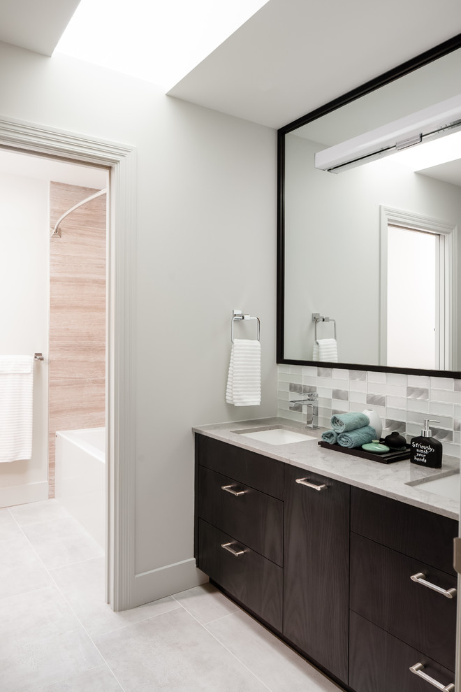 Medium sized traditional family bathroom in Vancouver with flat-panel cabinets, black cabinets, an alcove bath, a shower/bath combination, a one-piece toilet, grey tiles, porcelain tiles, grey walls, porcelain flooring, a submerged sink, engineered stone worktops, grey floors, a shower curtain and grey worktops.