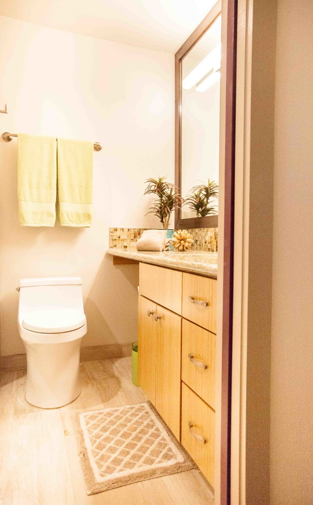 Exempel på ett litet modernt badrum med dusch, med släta luckor, skåp i ljust trä, en toalettstol med hel cisternkåpa, beige väggar, klinkergolv i porslin, ett undermonterad handfat, granitbänkskiva och beiget golv