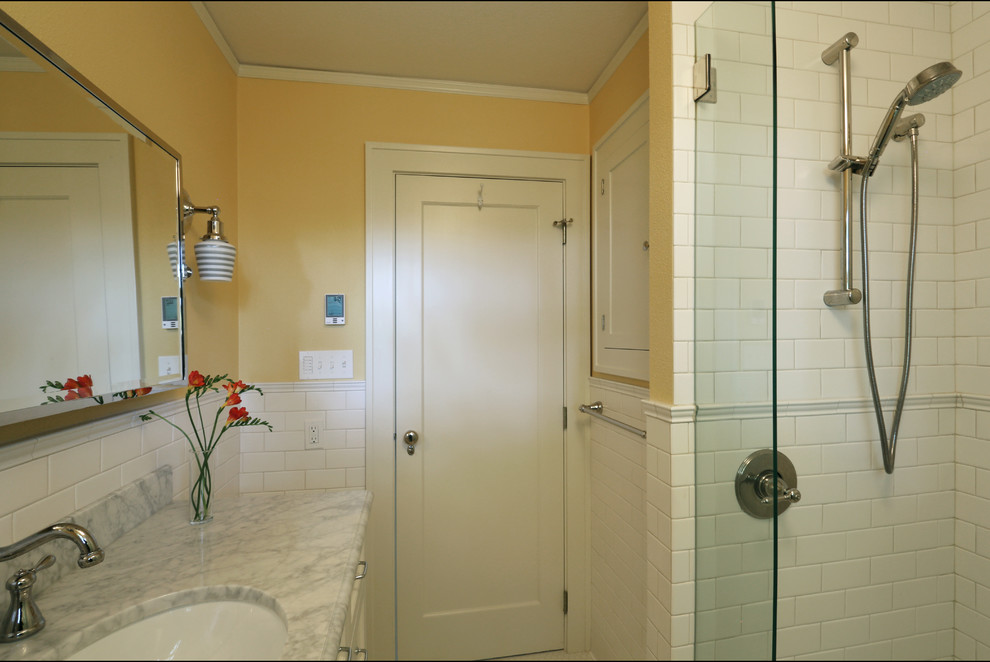На фото: маленькая ванная комната в классическом стиле с врезной раковиной, мраморной столешницей, белой плиткой, керамической плиткой, желтыми стенами, полом из керамической плитки и душевой кабиной для на участке и в саду