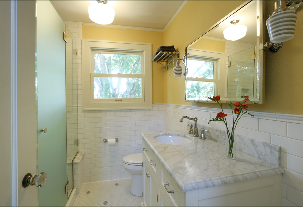 Стильный дизайн: маленькая ванная комната в классическом стиле с врезной раковиной, фасадами в стиле шейкер, белыми фасадами, мраморной столешницей, белой плиткой, керамической плиткой, желтыми стенами, полом из керамической плитки и душевой кабиной для на участке и в саду - последний тренд