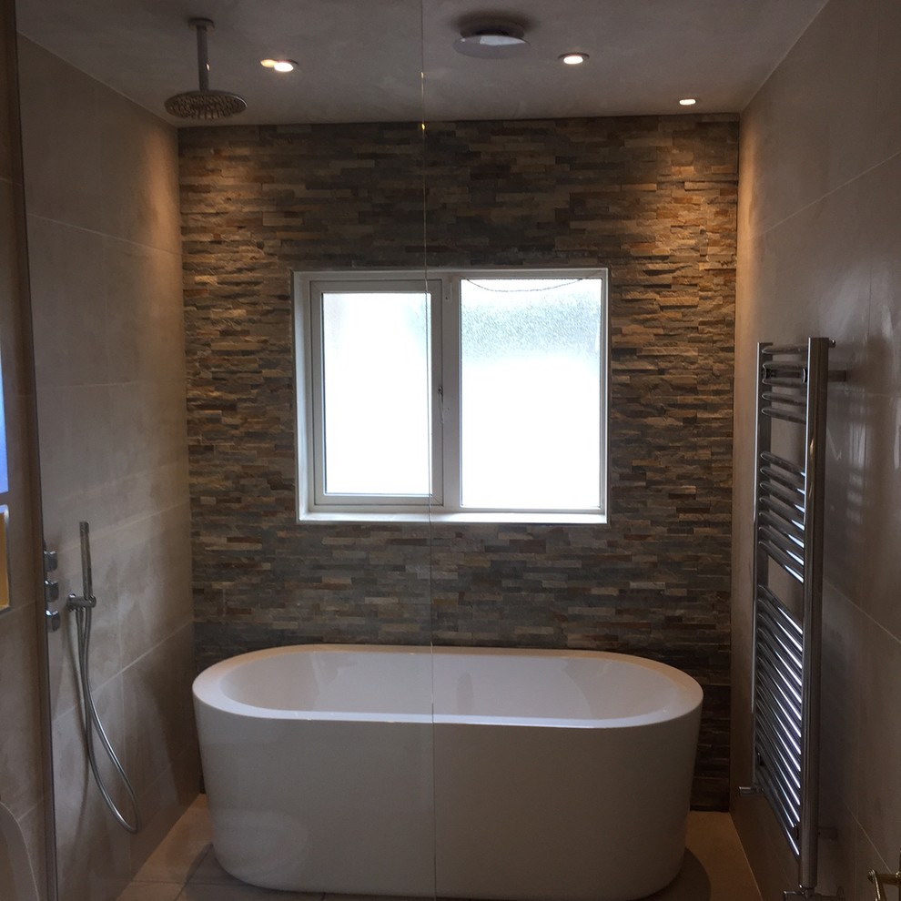Example of a mid-sized trendy beige tile and ceramic tile ceramic tile bathroom design in Dublin with glass-front cabinets, white cabinets, a wall-mount toilet, beige walls, a wall-mount sink and tile countertops