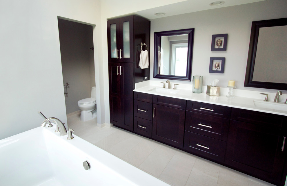 Medium sized modern bathroom in Chicago with a submerged sink, shaker cabinets, dark wood cabinets, a freestanding bath, an alcove shower, a one-piece toilet, grey tiles, porcelain tiles and porcelain flooring.