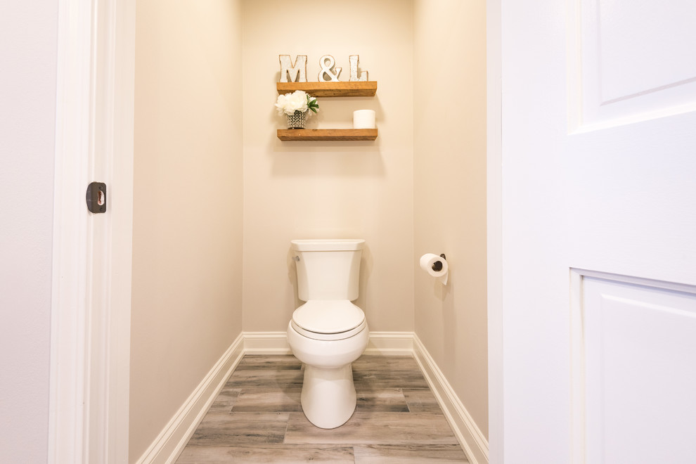 Idée de décoration pour un grand WC et toilettes tradition en bois foncé avec un placard avec porte à panneau encastré, WC séparés, un carrelage beige, un carrelage métro, un mur beige, un sol en carrelage de porcelaine, un lavabo encastré, un plan de toilette en granite et un sol gris.