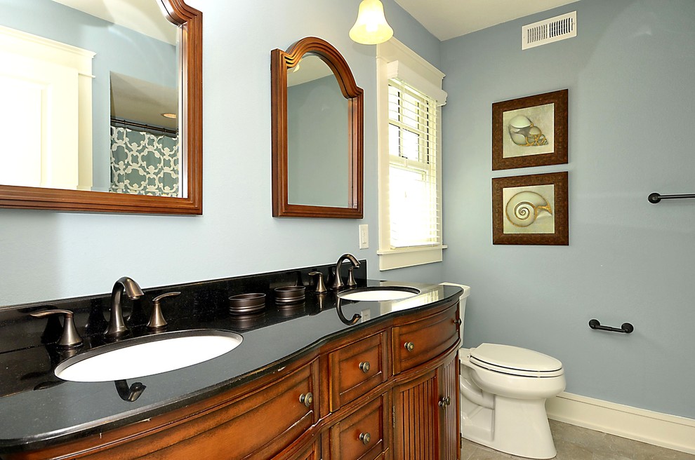 Idée de décoration pour une salle de bain principale marine en bois brun de taille moyenne avec un placard en trompe-l'oeil, une baignoire en alcôve, un combiné douche/baignoire, WC séparés, un mur bleu, un sol en carrelage de céramique, un lavabo encastré et un plan de toilette en granite.