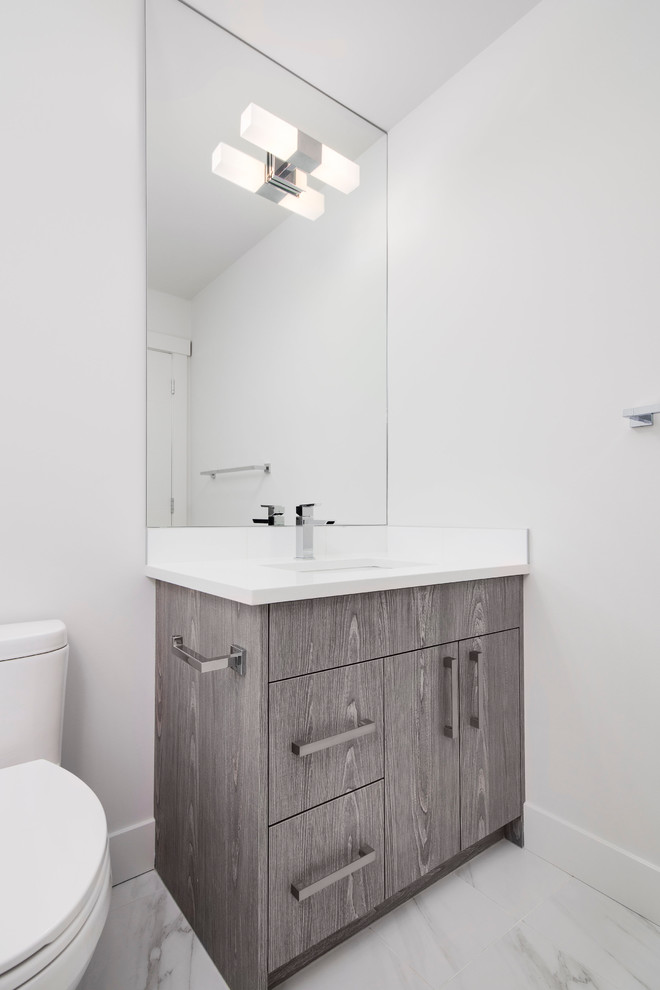 Mid-sized trendy 3/4 white tile and ceramic tile ceramic tile bathroom photo in Calgary with a drop-in sink, flat-panel cabinets, light wood cabinets, quartz countertops, a one-piece toilet and gray walls