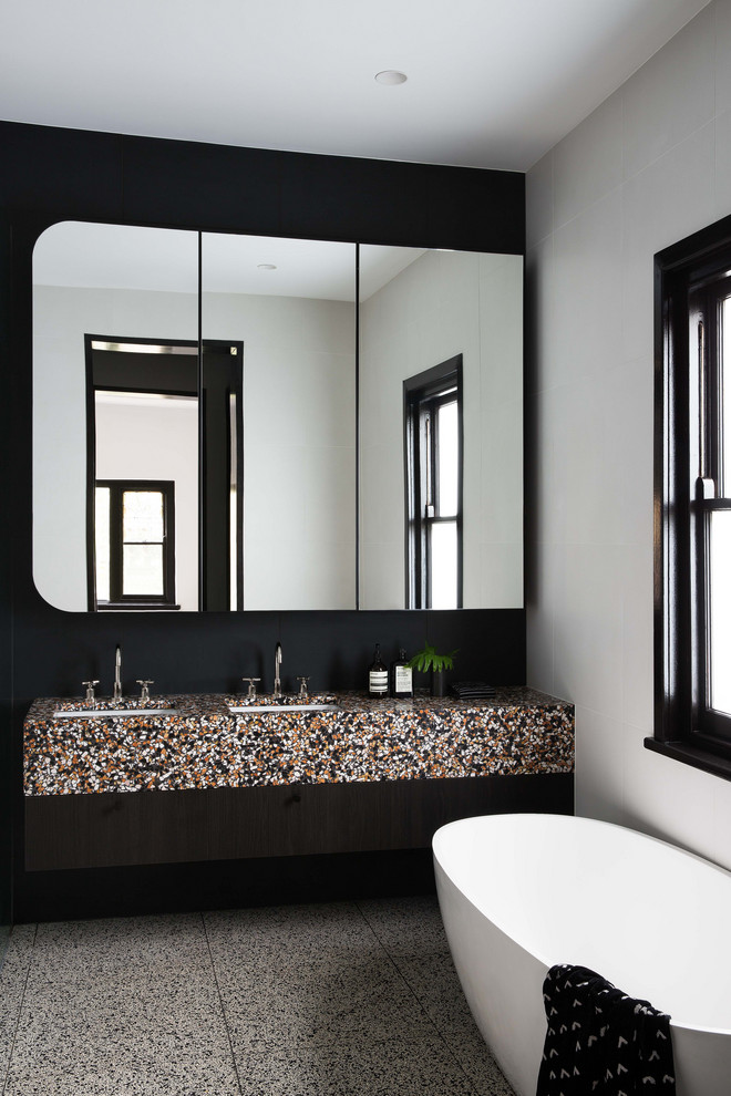 На фото: ванная комната в современном стиле с разноцветной столешницей, отдельно стоящей ванной, белыми стенами, врезной раковиной и серым полом с