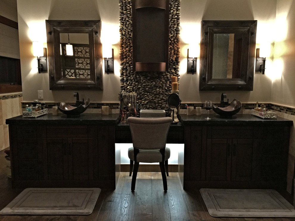 Пример оригинального дизайна: большая главная ванная комната в стиле рустика с фасадами в стиле шейкер, искусственно-состаренными фасадами, отдельно стоящей ванной, угловым душем, унитазом-моноблоком, разноцветной плиткой, каменной плиткой, полом из травертина, настольной раковиной и столешницей из гранита